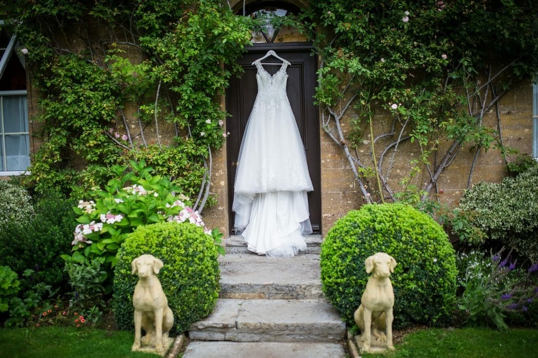 A wedding dress hanging from the door of the Georgian hotel at Haselbury Mill Wedding Venue in Crewkerne, taken by Somerset Photographer
